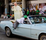 Images from downtown Indy's St. Patrick's day parade - a car with a pope cutout and a person hopping in