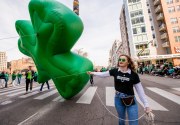 Images from downtown Indy's St. Patrick's day parade - woman holding clover balloon