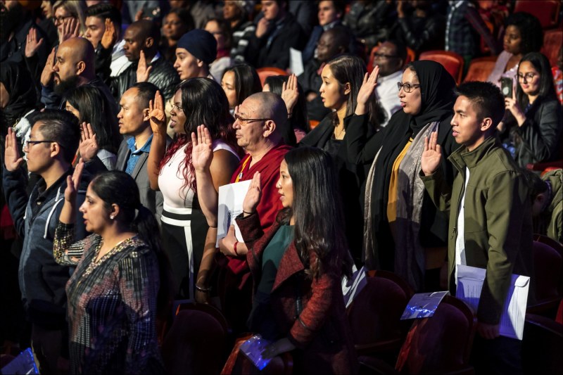 Some 98 new United States citizens, including Burmeese Chin, take the oath of citizenship before U.S. District Court Judge Robyn Moberly at the Palladium Center for the Performing Arts in Carmel, Indiana.  Twenty-five year old Cdin Thanga Cherput (green jacket lower left) was among five Chin visible in this photograph.