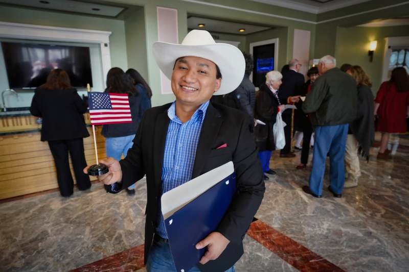 Burmese Chin refugee Jones Zaa Thang, an Amazon.Com worker, displays his U.S. flag after taking the oath of citizenship at a naturalization ceremony at the Palladium Center for the Performing Arts in Carmel, Indiana.  Jones Zaa Thang came to the United States five years ago.