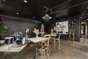 a drum and guitar sit next to a garage door and tables in an events venue