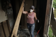 Mina lifting a piece of wood during the demo. Renovated by Mina & Karen; as seen on Good Bones Season 7