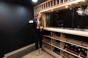 Mina Hawk pours a glass of wine in the basement wine cellar and speakeasy of the home.