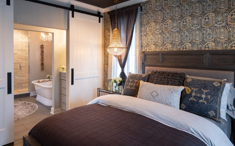 The main suite breaks with convention by devoting equal space to the bedroom and bathroom, separated by sliding doors.