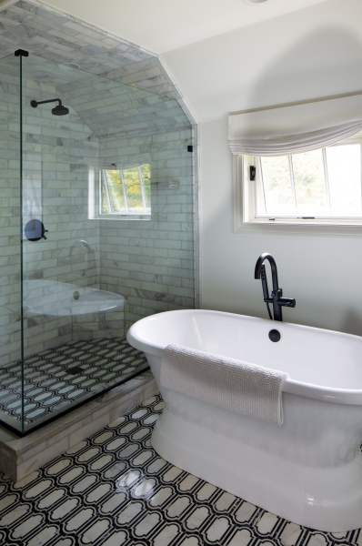 The suite’s bathroom blends traditional and contemporary with marble mosaic tile in classic black and white.