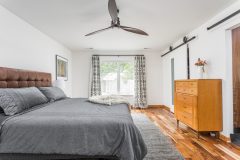 “Barn” doors hiding the master suite’s bath and closet have an appropriately midcentury, not farmhouse, look.