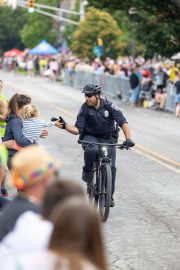 an IMPD officer on a bike high-fiving a child