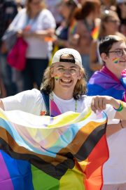 Photos from Indy Pride Parade 2022 a smiling person holds a flag