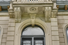 Detail of four children's faces appear above the front entry