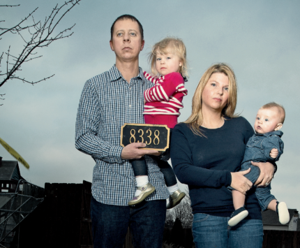 A young couple with their two babies, their address marker and a painting