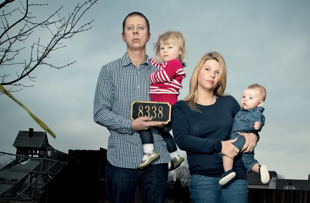 A young couple with their two babies, their address marker and a painting