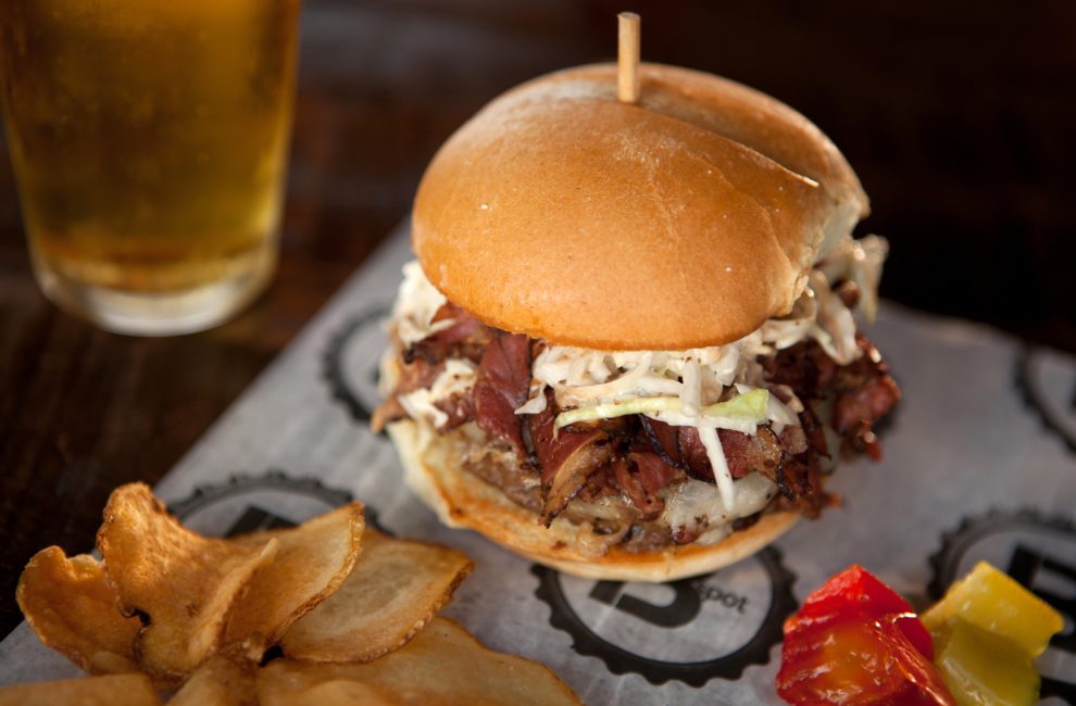 The bestselling Fat Doug at B Spot Burgers gets topped with coleslaw, pastrami, mustard, and Swiss.