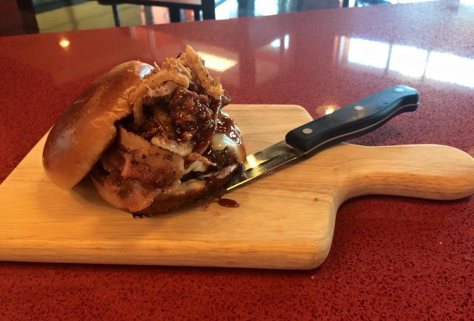 The BBQ Burger at Flamme Burger, topped with jalapenos, Swiss cheese, chipotle barbecue sauce, and onion straws.