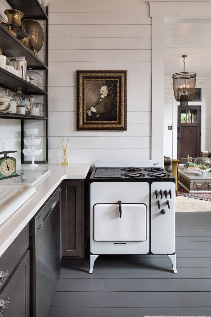 Kitchen with white wood walls (shiplap) and vintage stove.