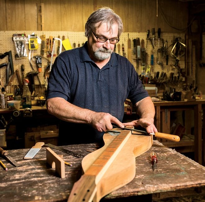 Man, Bill Berg crafts a dulcimer, an hourglass shaped musical instrument.