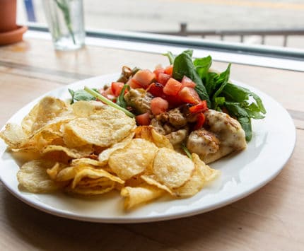 Chicken with greens and chips at SoBro Cafe