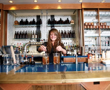 Bartender mixing cocktails at the bar at Spoke & Steele