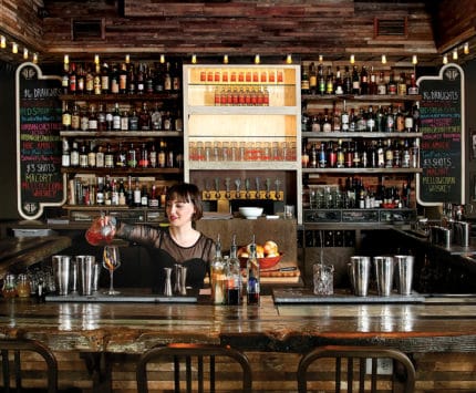 Bar with female bartender pouring a cocktail at Thunderbird