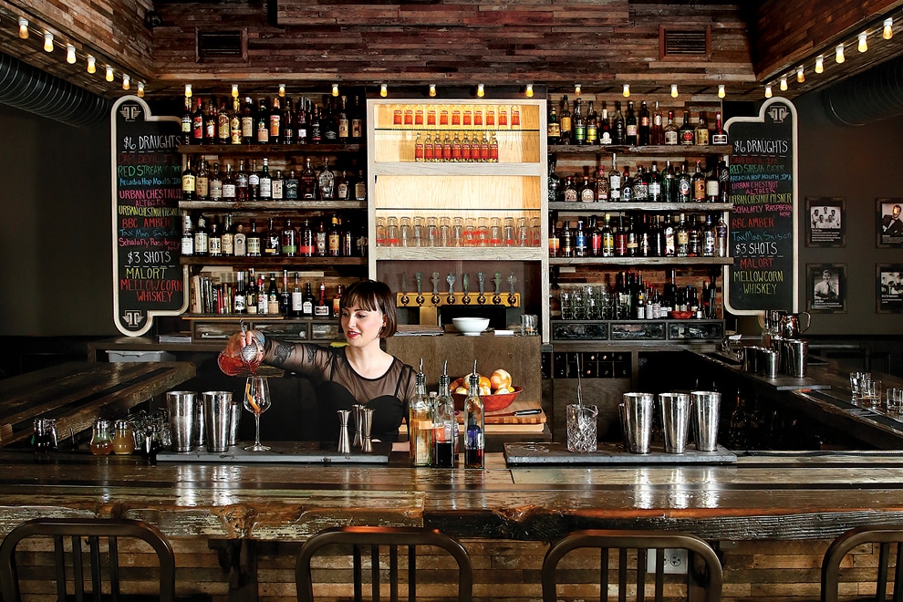 Bar with female bartender pouring a cocktail at Thunderbird