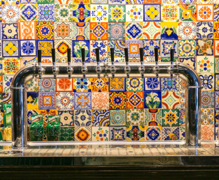 Txuleta taps with colorful tile wall