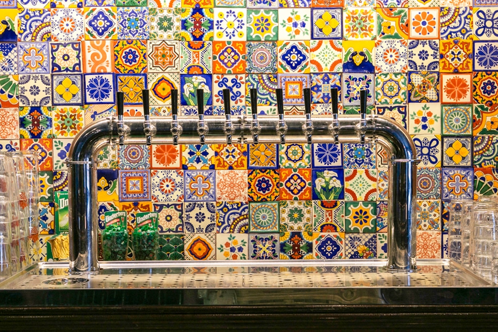 Txuleta taps with colorful tile wall