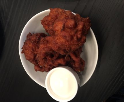 Picture of orange carrot fritters with a white dipping sauce