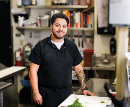 Man standing in a kitchen and smiling.