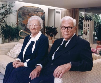 Photograph of two elderly people sitting on a couch together.