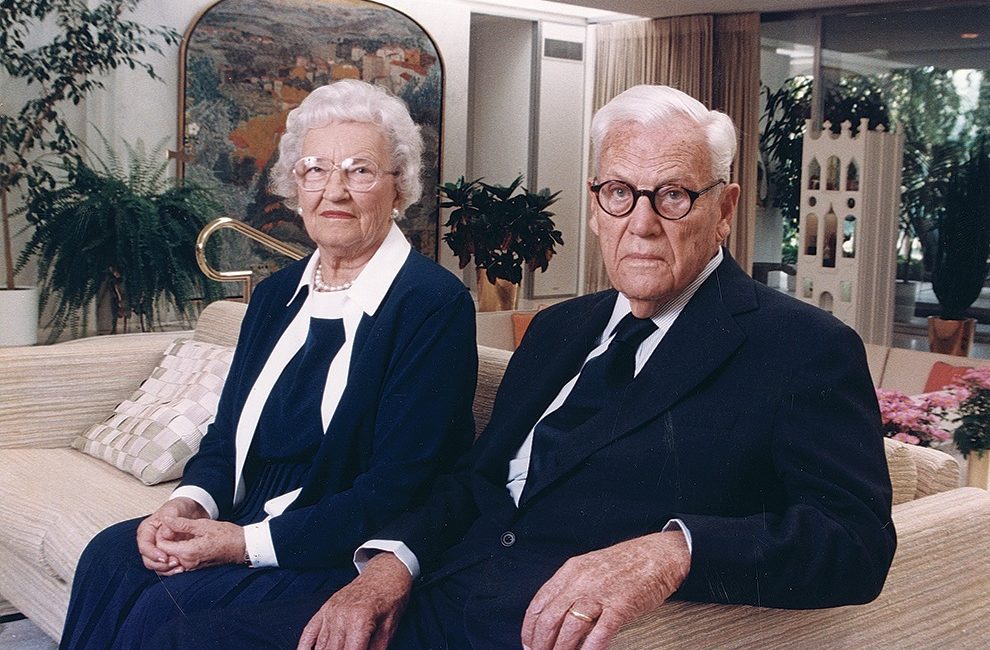 Photograph of two elderly people sitting on a couch together.