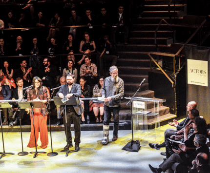 3 people at podiums in front of audience