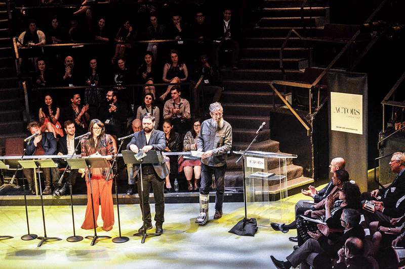 3 people at podiums in front of audience