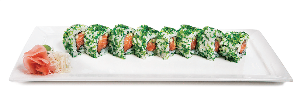 A long sushi roll made with salmon and wrapped with white rice and green fish roe line a long plate.