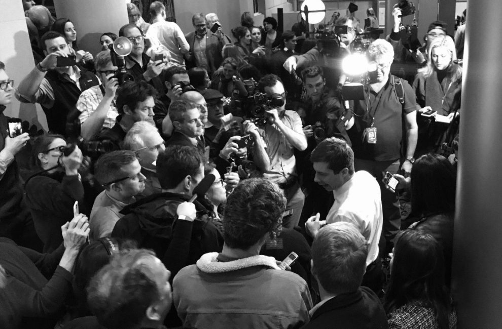 Reporters surround presidential candidate Pete Buttigieg.