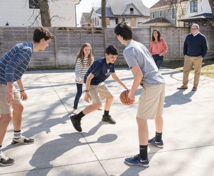 A family plays backyard basketball.
