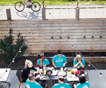 People sit around an outdoor patio table at a restaurant.