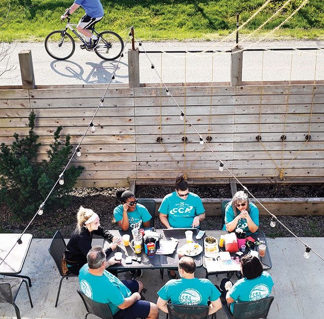 People sit around an outdoor patio table at a restaurant.