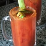 A large mug of Bloody Mary garnished with the requisite celery stalk.