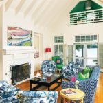 A white living area stuffed with patterned blue furniture.