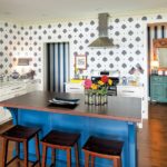 A white and blue kitchen with a wooden countertop island.