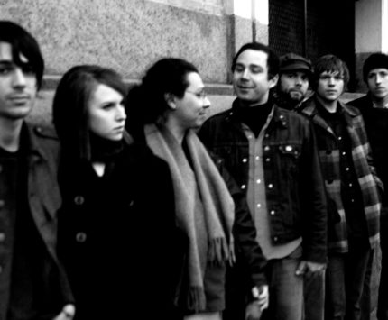 Black and white photo of members of the band along a city street.