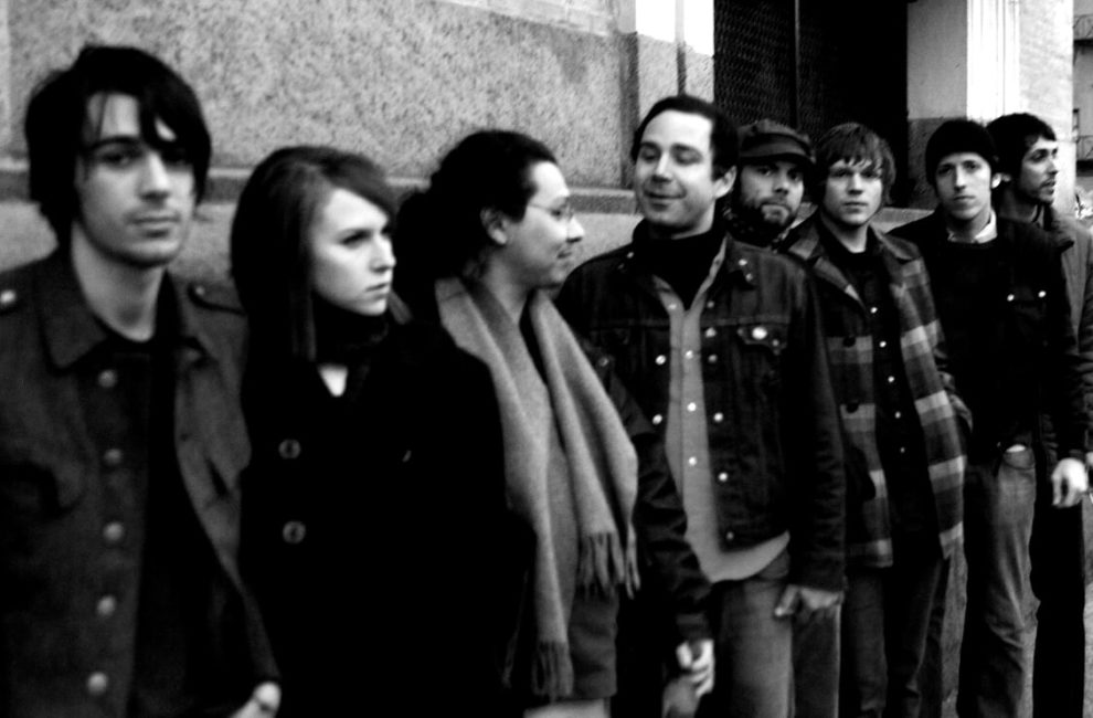 Black and white photo of members of the band along a city street.