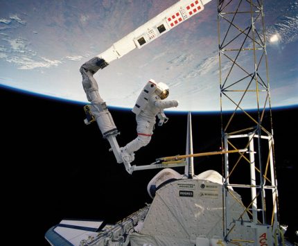 An astronaut takes a space walk outside of the shuttle.