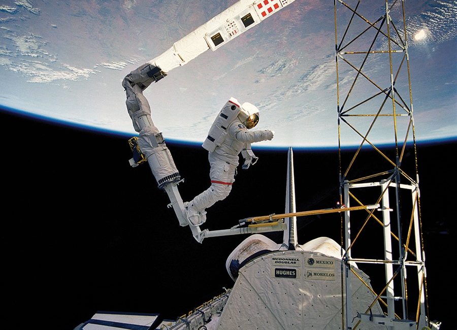 An astronaut takes a space walk outside of the shuttle.