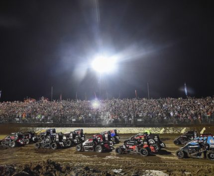 Cars race around the dirt track at Indianapolis Motor Speedway