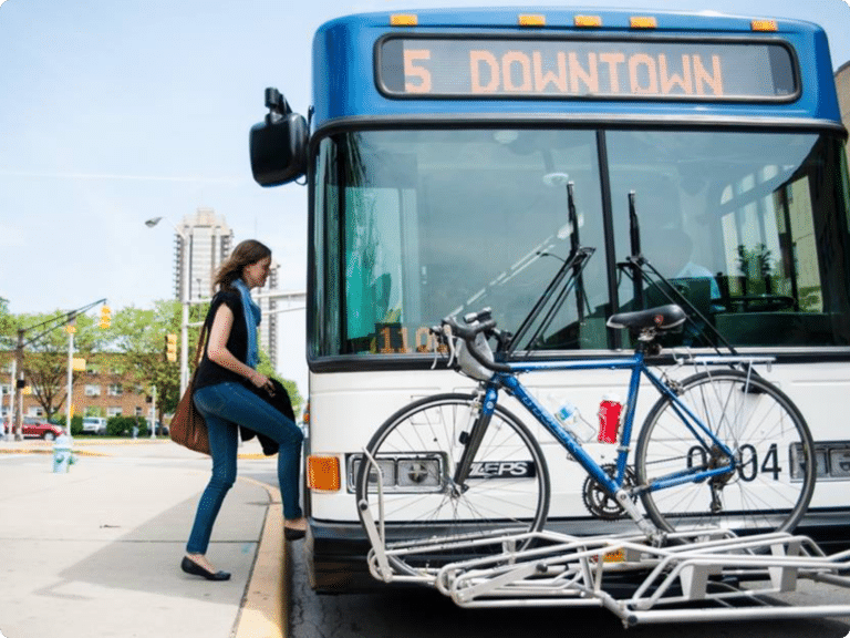 A person boards a city bus from the sidewalk