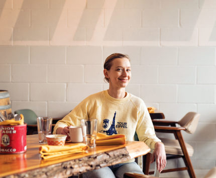 A woman in a sweatshirt sitting at a table
