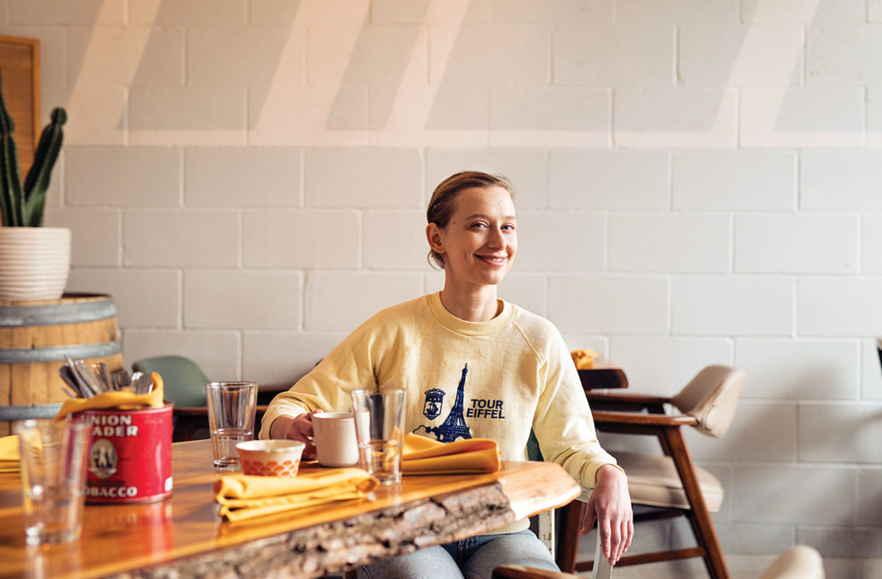 A woman in a sweatshirt sitting at a table