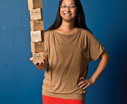 Carrie Abbott of Newfangled Confections holds boxes of her signature Frittle candy.