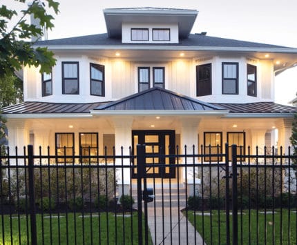 A home lit up at dusk on a gated lot