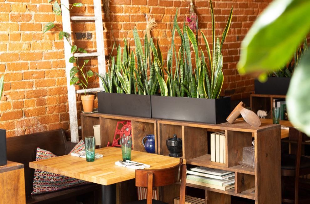 A small dining table placed next to a brick wall and a ladder